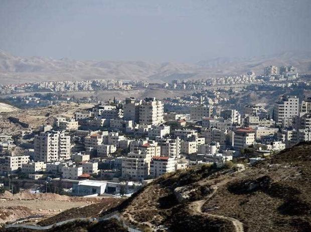 view of arab village with Israeli settlements on hilltops behind