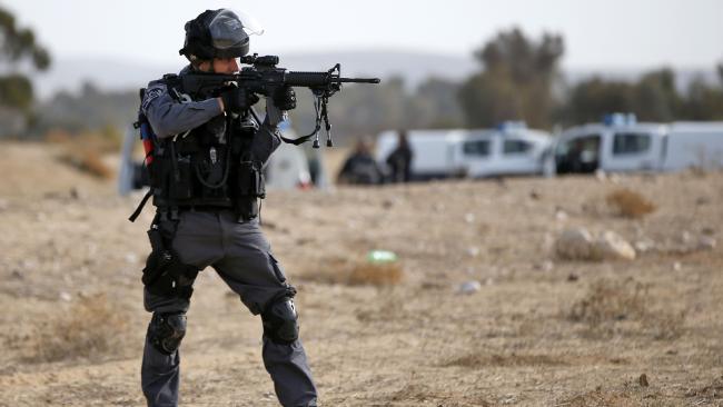 Israeli policeman aiming his weapon.