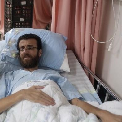 Hunger-striking jailed journalist Muhammad al-Qiq in a hospital bed