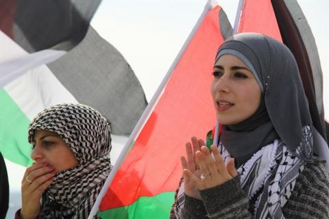 Palestinian women in front of their flag