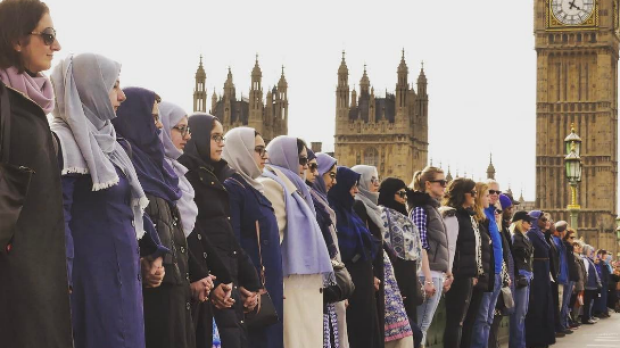 Women holding hands on bridge near Westminster
