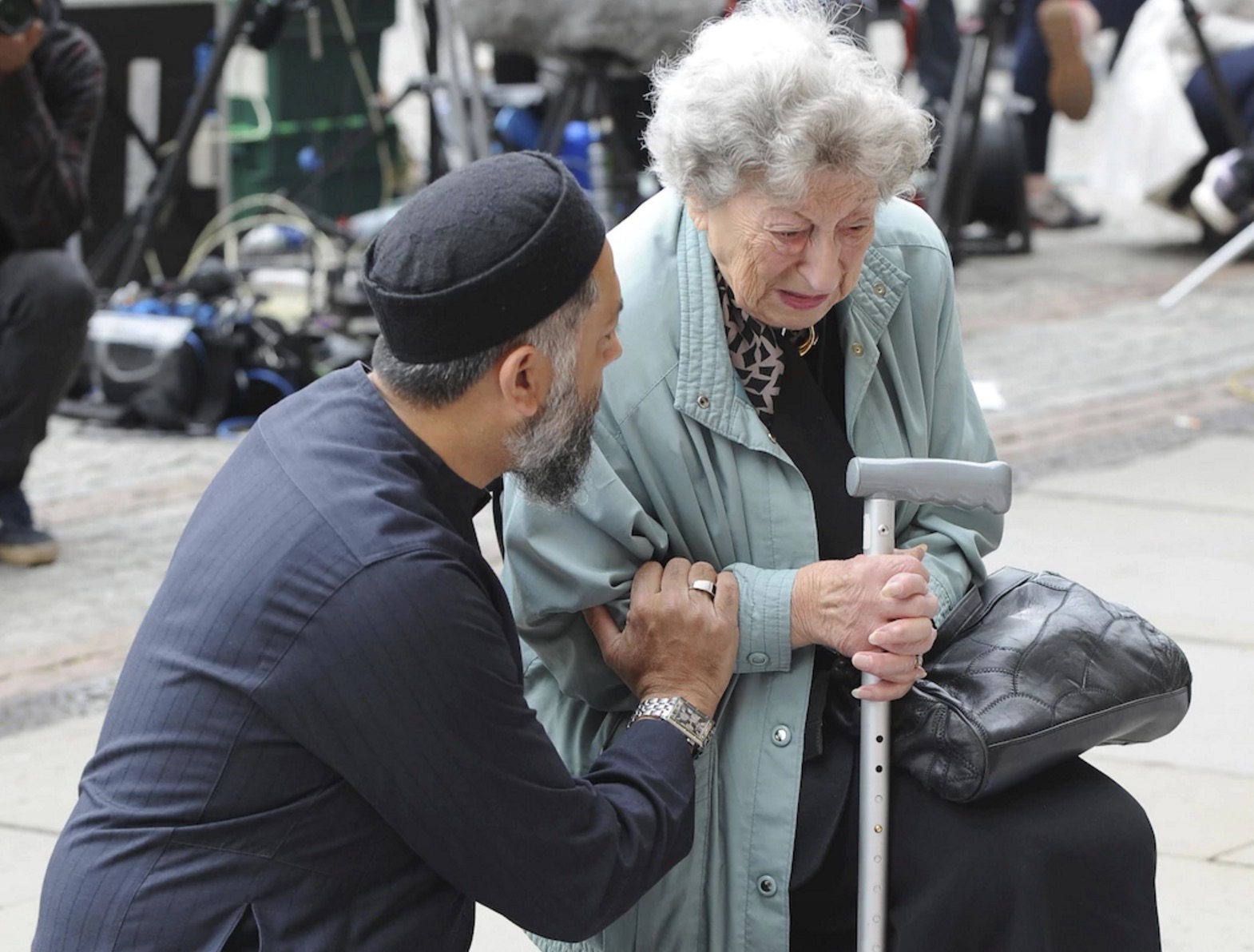muslim man comforting old jewish woman at manchester memorial