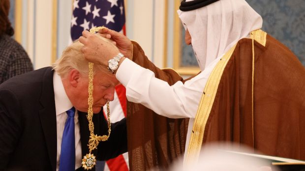 Trump bowing, having medal placed round his neck by Saudi King