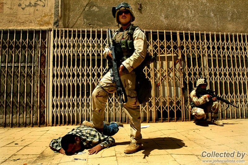 US marine standing with his foot on an Iraqi lying on the ground