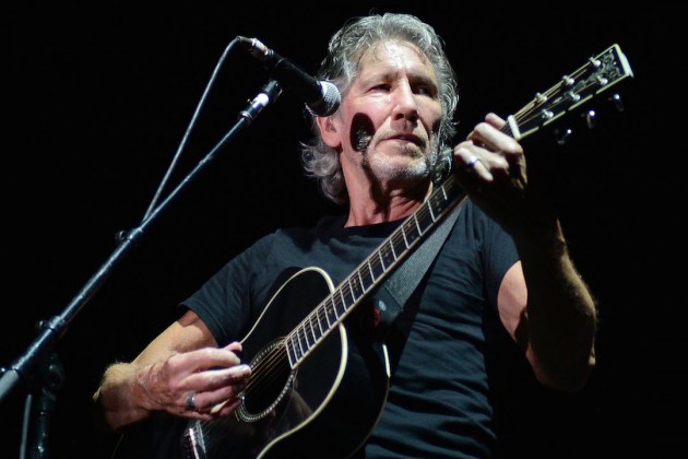 Roger Waters playing guitar on stage