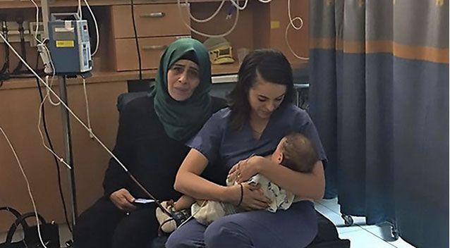 nurse feeding with arab woman sitting next to her