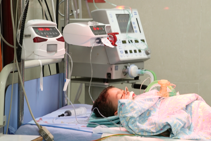 baby lying in hospital bed hooked up to machines