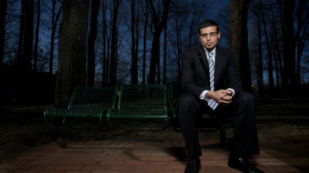 Manny Waks sitting on a park bench in the dark