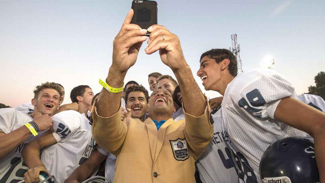 israeli kids standing around the nfl player taking a selfie