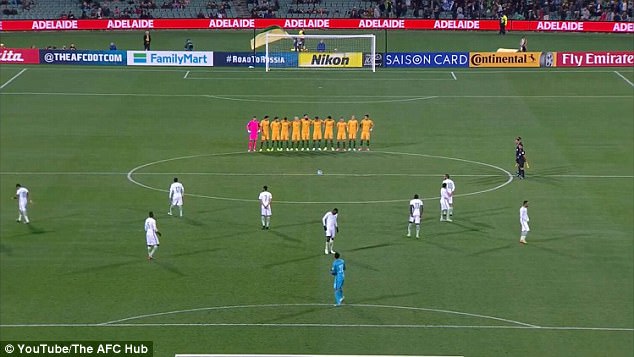 aussie soccer team standing for minute silence and saudi players scattered across the field