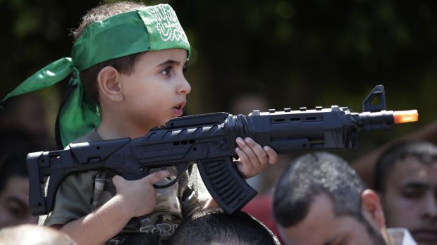 small palestinian boy holding fake gun