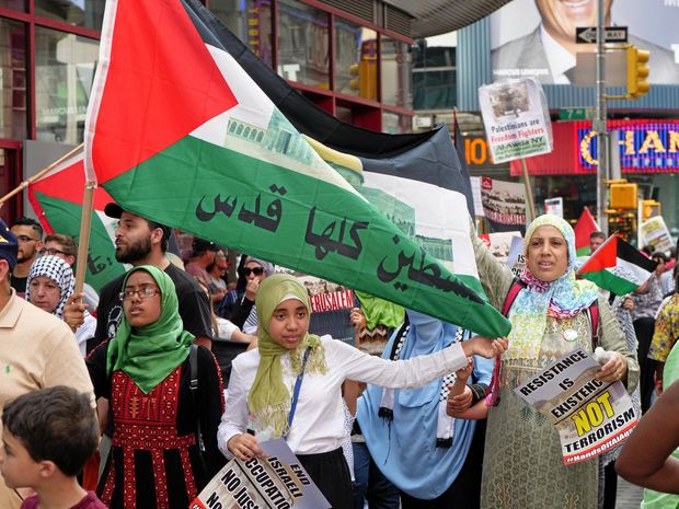 women in headscarves protesting with palestinian flags
