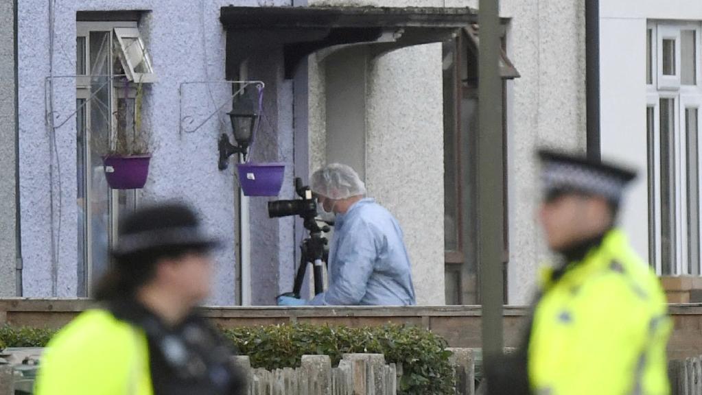 forensic photographer at work with police in foreground