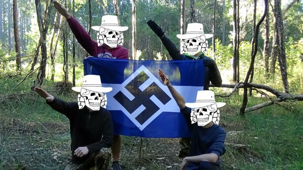 neon-nazis posing with a swastika flag