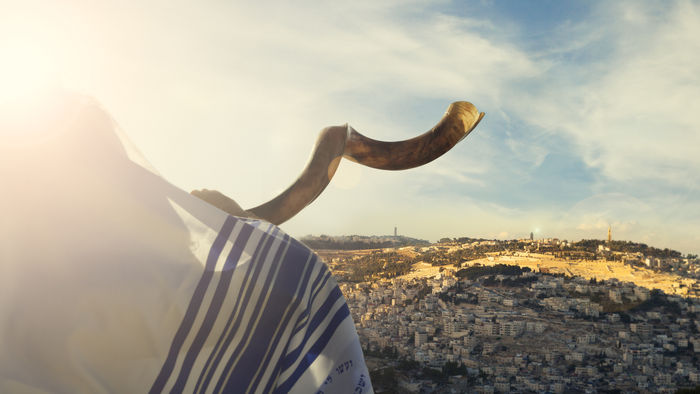 Shofar being blown overlooking a hill in israel