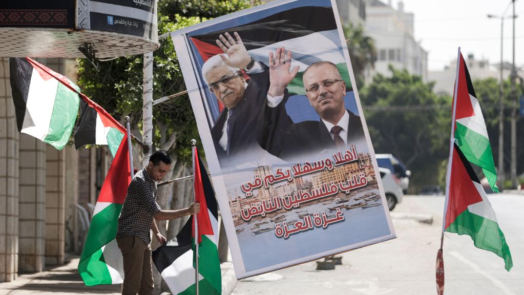 man setting up palestinian flags and supportive posters of reconciliation