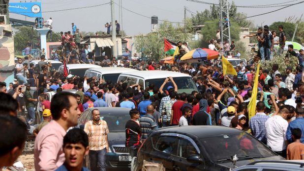 palestinians crowding around the vans of the west bank PM in gaza