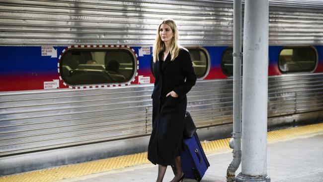Ivanka Trump walking along a train platform pulling a suitcase