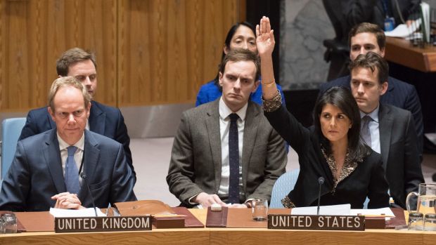 Haley at the UN voting with her hand up with others sitting by her