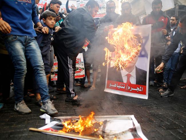 protestors burning posters of Trump
