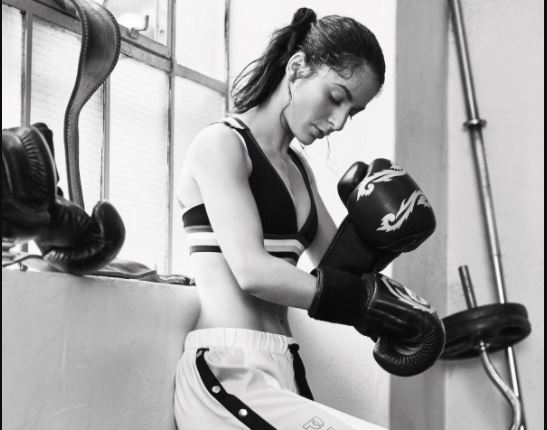 rita putting on boxing gloves in a stylish photo