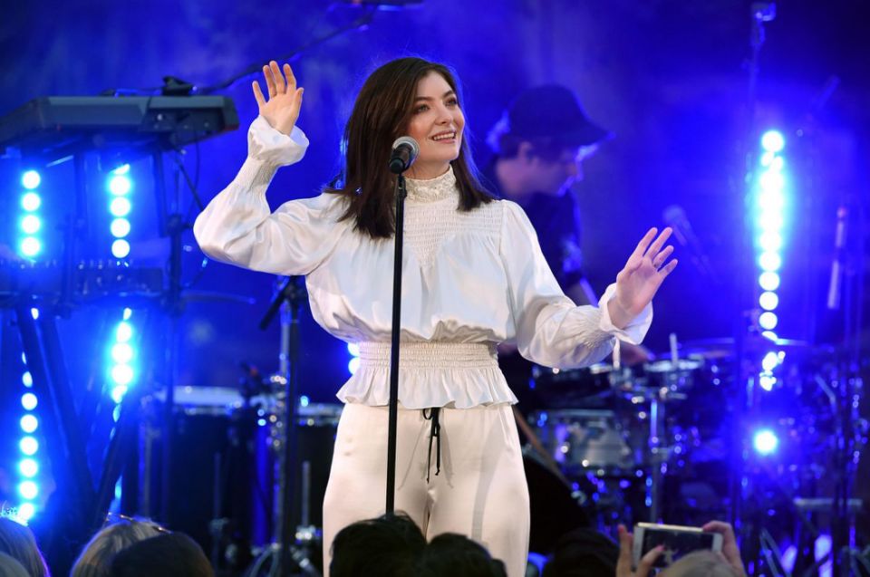 Lorde on stage, behind microphone