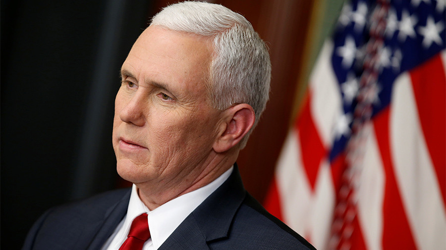 Headshot of Mike Pence, American flag behind, looking pensive into the distance