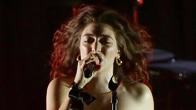 Lorde close up, singing on stage into microphone