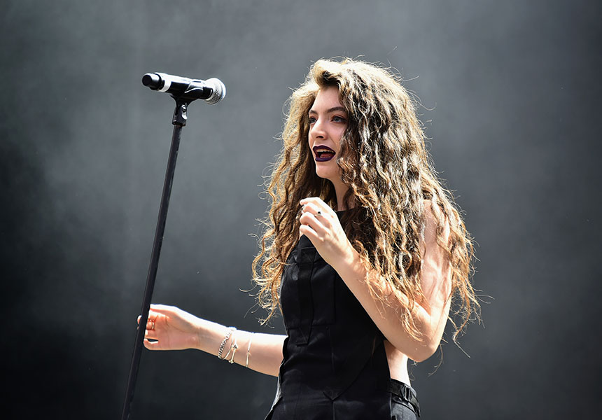 Lorde on stage near a microphone