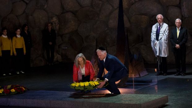 Prime Minister Turnbull and wife both bending down to lay wreath at yad vashe