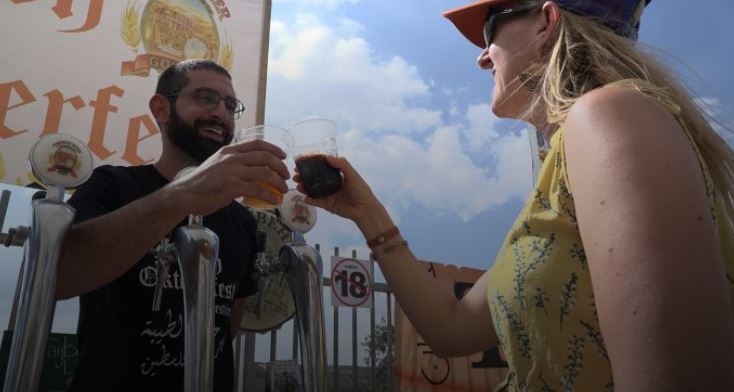 palestinian man and woman holding up beers