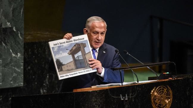 Bibi holding up newspaper article at UN podium