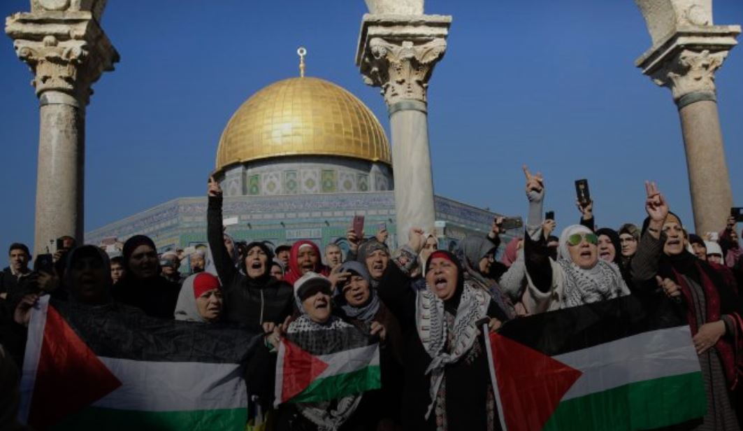 Palestinians demonstrating with flags in front of Al Aqsa Mosque