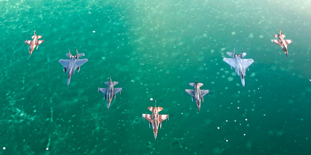 fighter planes in formation over the sea