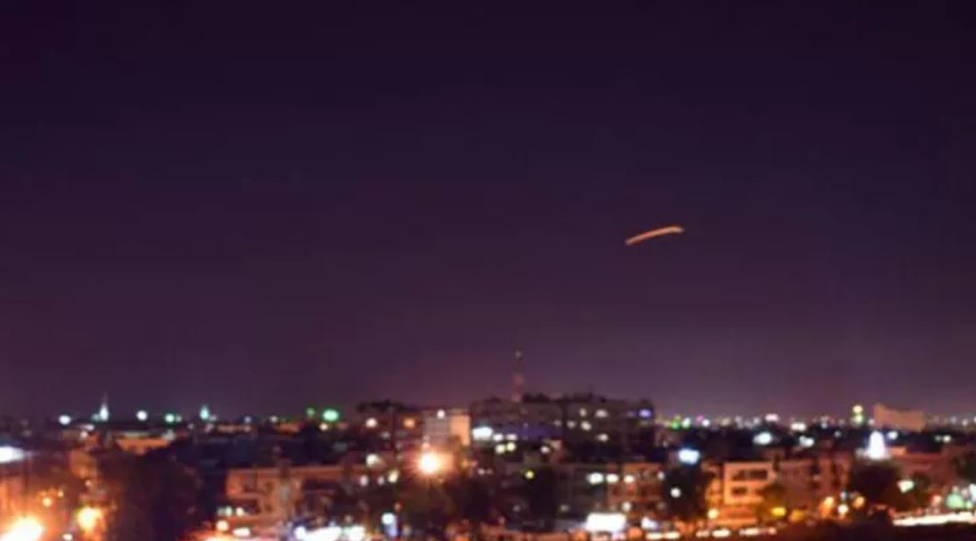skyline at night with the streak of light of an air defense missile in the air