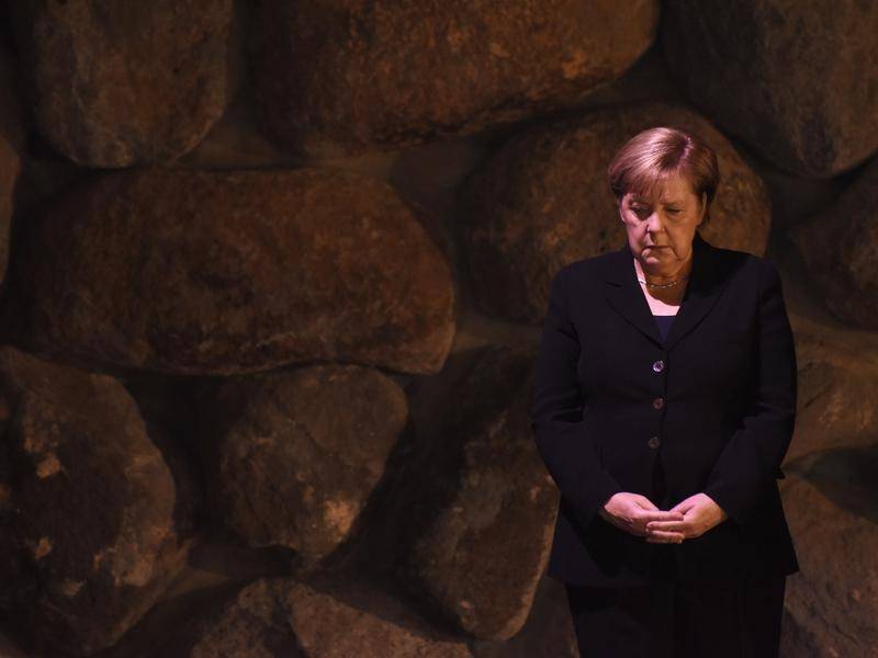 Merkel standing alone looking down at Yad Vashem